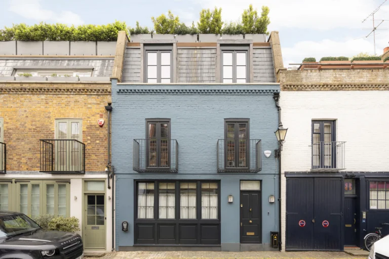 Blue-painted mews house in Notting Hill with Juliet balconies, dormer windows and rooftop planting.